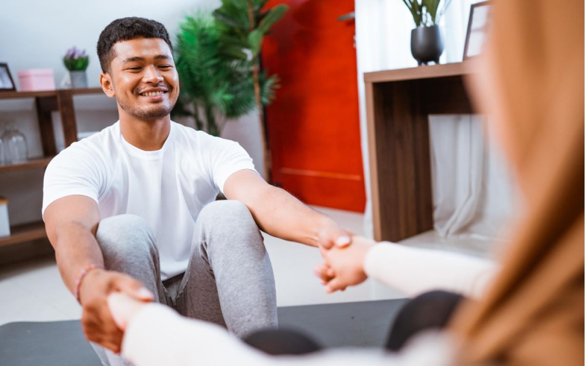 A man holding hands in a meditation session