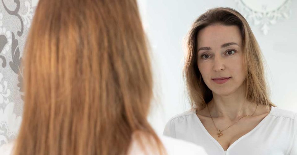 A woman looking at herself in the mirror